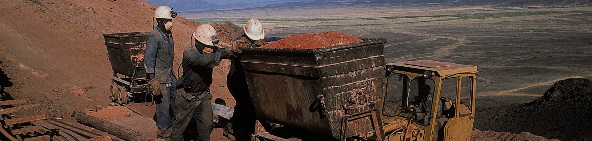 Mineurs transportant le minerai d’or sur rail sous le ciel de la mine d’Hassaï (Soudan, 1980). © BRGM